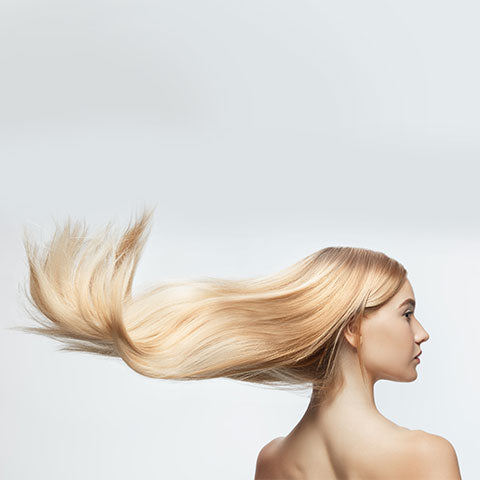 A women's hair being blown by a blow dryer with nozzle